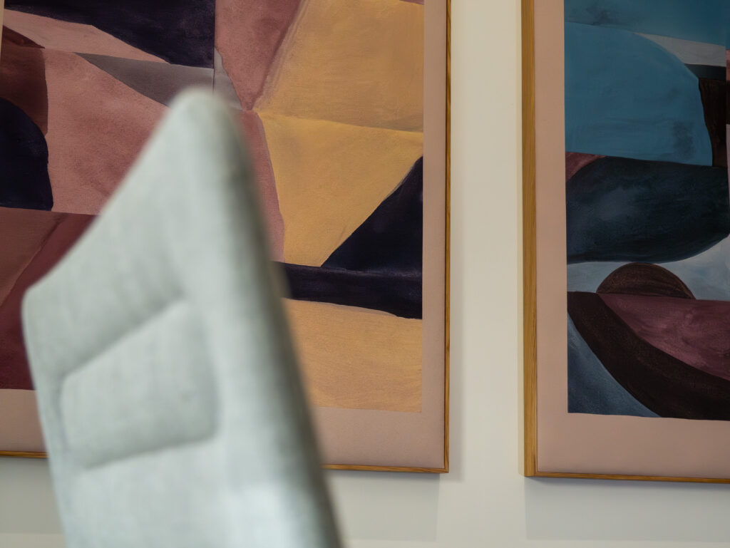 A chair and Dezibel Art, acoustic art panels on the wall.